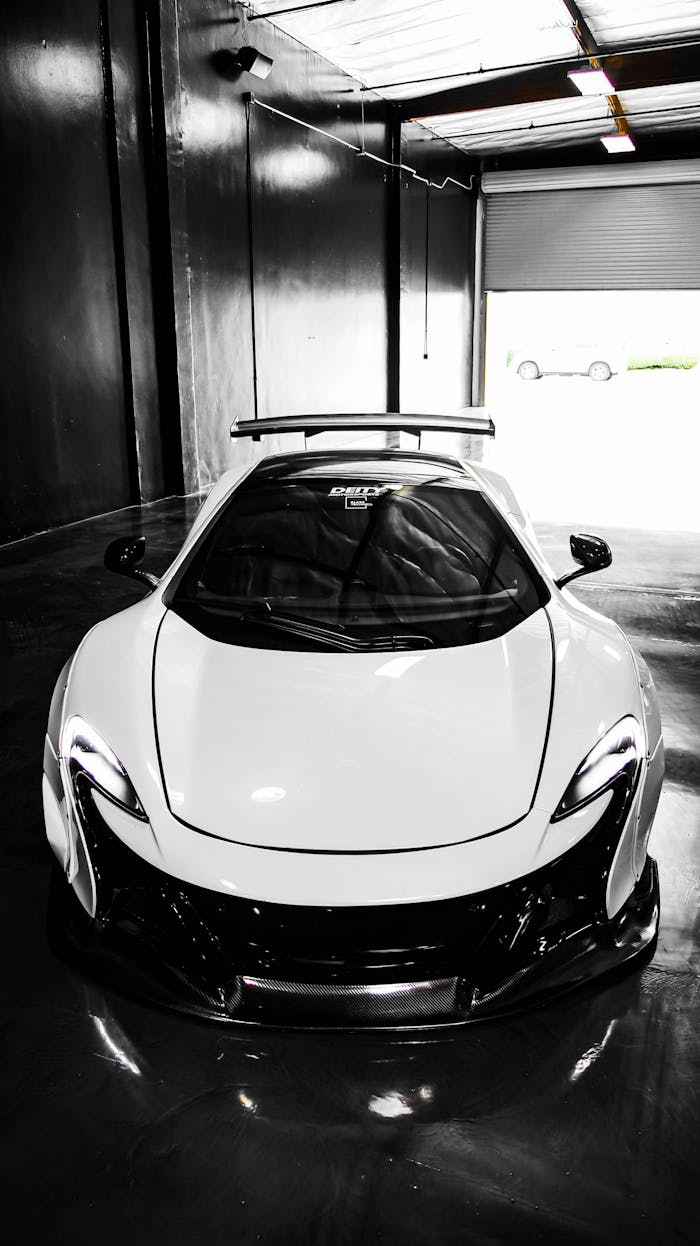 White sports car in a modern industrial garage, perfect for luxury automotive enthusiasts.